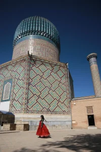 Woman walking by building against sky